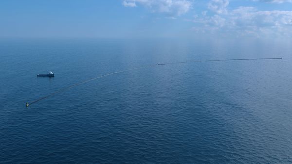The Ocean Cleanup computer rendering, system with support vessel. Credits: Erwin Zwart / The Ocean Cleanup
