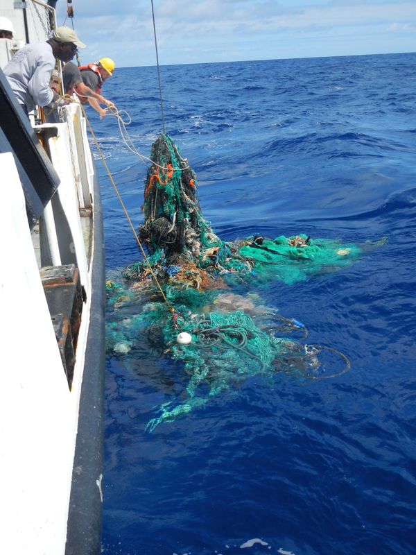 Mega Expedition mothership R/V Ocean Starr crew pulling a ghost net from the Pacific Ocean, 2015.